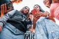 View from below. With phone. Group of young cheerful friends having fun together. Party outdoors Royalty Free Stock Photo