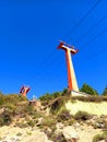 View from below of ski lift on Escape Mountain under blue sky. Constructions and engineering. Wiring and power lines for chair