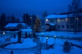 View of bench against christmas tree and shining lantern through snowing. Blue tone. Night shot. Royalty Free Stock Photo