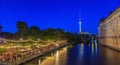 View on Berlin television tower and open air beer garden at shore of river Spree during evening twillight in summer