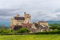 View of the Beynac Castle in the Dordogne Valley under an overcast expressive sky