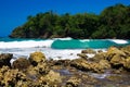 View beyond sharp rocks on turquoise rough sea with wave breakers and strong surf - Blue lagoon, Portland, Jamaica