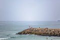 View of a big seawall on atlantic ocean and people enjoying the view and fishing