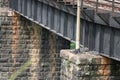 A view of the black bridge rest on the huge supports which made by stone blocks and cement.