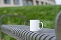 A blank white coffee mug on the park bench Royalty Free Stock Photo