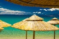 Yellow straw beach umbrellas and azure water, Pefkohori, Greece