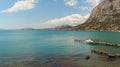 View of the blue Black Sea, high cliff and white pleasure boat at the pier, in sunny weather and cloudy sky