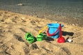 Blue bucket with the red hilt laying on the beach