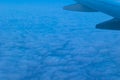 View of the blue cloudy sky from the height of flight above the clouds from the airplane window. Royalty Free Stock Photo