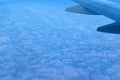 View of the blue cloudy sky from the height of flight above the clouds from the airplane window Royalty Free Stock Photo
