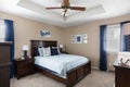 View of a blue-decorated home bedroom wooden interior with carpet-covered floor