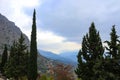 View of blue misty mountians and valley and twisting road framed by cedar and popular trees from ruins at Delphi Greece Royalty Free Stock Photo