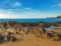 View of blue sea with stones and fishing boats