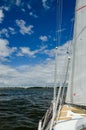 View of the blue sea water from the side of a sailboat with rigging and sails Royalty Free Stock Photo