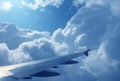 View of the blue sky and clouds on the airplain from window. Wing of airplain flying over the clouds