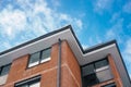 View of blue sky with clouds from bottom to top corner of roof with downspout Royalty Free Stock Photo