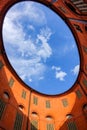 View of blue sky and clouds through oval rooftop of public theater building in Ferrara, Italy for commercial real estate concept Royalty Free Stock Photo