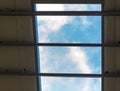 View of the blue sky with clouds through the roof of an industrial hall. Royalty Free Stock Photo