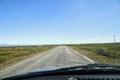 View on blue sky and grey road from the car front window in early mourning. Driving car during sunshine in the tundra in Norway. Royalty Free Stock Photo