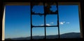 View of the blue sky and hills from the broken window of the abandoned cement factory