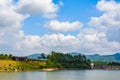 View of blue sky, white clouds and green hills and forest at outdoor reservoir Royalty Free Stock Photo
