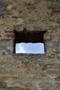 View of the blue sky through the window of the loophole in the wall of an ancient fortress. Copy space.