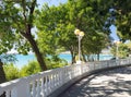 View on blue water in sea bay through white stone balustrade from promenade on sunny day in Velvet season. Decorative