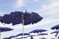 View of blue-wind-driven sea umbrellas with sky