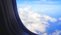 View of blur sky with white clouds through airplane window. Sky and cloud background. Royalty Free Stock Photo