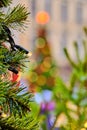 View of a blurred Christmas tree with garlands and lights through green branches Royalty Free Stock Photo