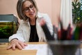 View through blurred colorful pencils holder to a fashion designer, dressmaker, mature elegant Caucasian business woman working at Royalty Free Stock Photo