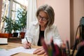 View through blurred pencils holder to a female fashion designer, dressmaker, senior elegant Caucasian business woman working at Royalty Free Stock Photo