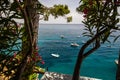 A view of boast floating on the blue water of the Mediterranean Sea through trees along the Amalfi Coast in Positano, Italy Royalty Free Stock Photo