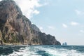 View from the boat on Capri island coast and faraglioni oceanic rock formation