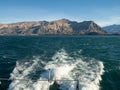 View from boat on Lake Wanaka with mountains and foamy wake