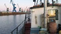 View from boat to seaport. Clip. Fishing or cargo boat sails to industrial seaport. Maritime business, shipping and