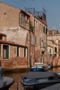 View of boats on channel under buildings in sunlight