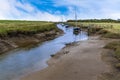 A view of boats moored along a muddy creek at Gibraltar Point near Skegness, UK