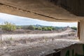 View of the border dividing strip through the embrasure in the concrete security separation fence on the border between Israel and Royalty Free Stock Photo