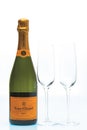 View of bottle of authentic french brut champagne Veuve Clicquot and two slim, tall and elegant champagne glasses.