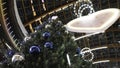 View from the bottom on the high Christmas fur tree decorated by blue and silver balls and garland of colorful lights Royalty Free Stock Photo