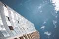 View from the bottom of office tower skycrapper building with glass windows in cloud blue sky Royalty Free Stock Photo