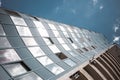 View from the bottom of office tower skycrapper building with glass windows in cloud blue sky Royalty Free Stock Photo