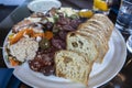 View of a bountiful selection of food on a charcuterie plate on a wooden table at a restaurant