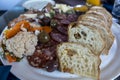 View of a bountiful selection of food on a charcuterie plate on a wooden table at a restaurant