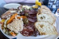 View of a bountiful selection of food on a charcuterie plate on a wooden table at a restaurant