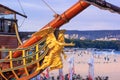 View of the bow and the figurehead of a stylized vintage sailboat close-up against the backdrop of the beaches of Varna