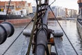 View from the bow of an old sailing ship with ropes and chains, overlooking a historic city waterfront. Royalty Free Stock Photo