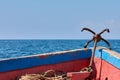 View of the bow of an old wooden boat sailing. Metal anchor, sea or ocean under clear sky Royalty Free Stock Photo