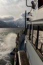 View from the bow of the yacht to the Kamchatka mountains. Sunbeams penetrate the sunset clouds. Concept of summer vacation at sea Royalty Free Stock Photo